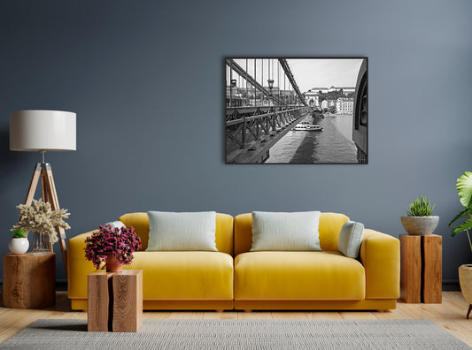 The Széchenyi Chain Bridge, Budapest. B&W, black and white with black frame, giclee canvas print in situ on a grey wall with a yellow sofa and wooden tones.
David Kitching KitchingArt
